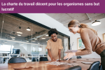 Image title says, "La charte du travail décent pour les organismes sans but lucratif." It's an image of two workers in a meeting room pointing at a paper on the table.